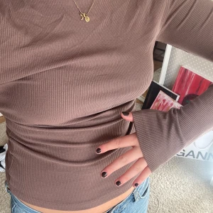Ribbstickad brun tröja  - Ribbstickad brun tröja från bikbok. Storlek M. Aldrig använd! Har en u-ringning, man kan ha åt båda hållen, så man antingen har u-ringningen fram eller i ryggen🥰