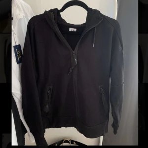 CP Company zip hoodie - Säljer CP company zip hoodie med tags osv. Tröjan är använd men fortfarande bra skick! Skriv vid intresse eller fler bilder🌟