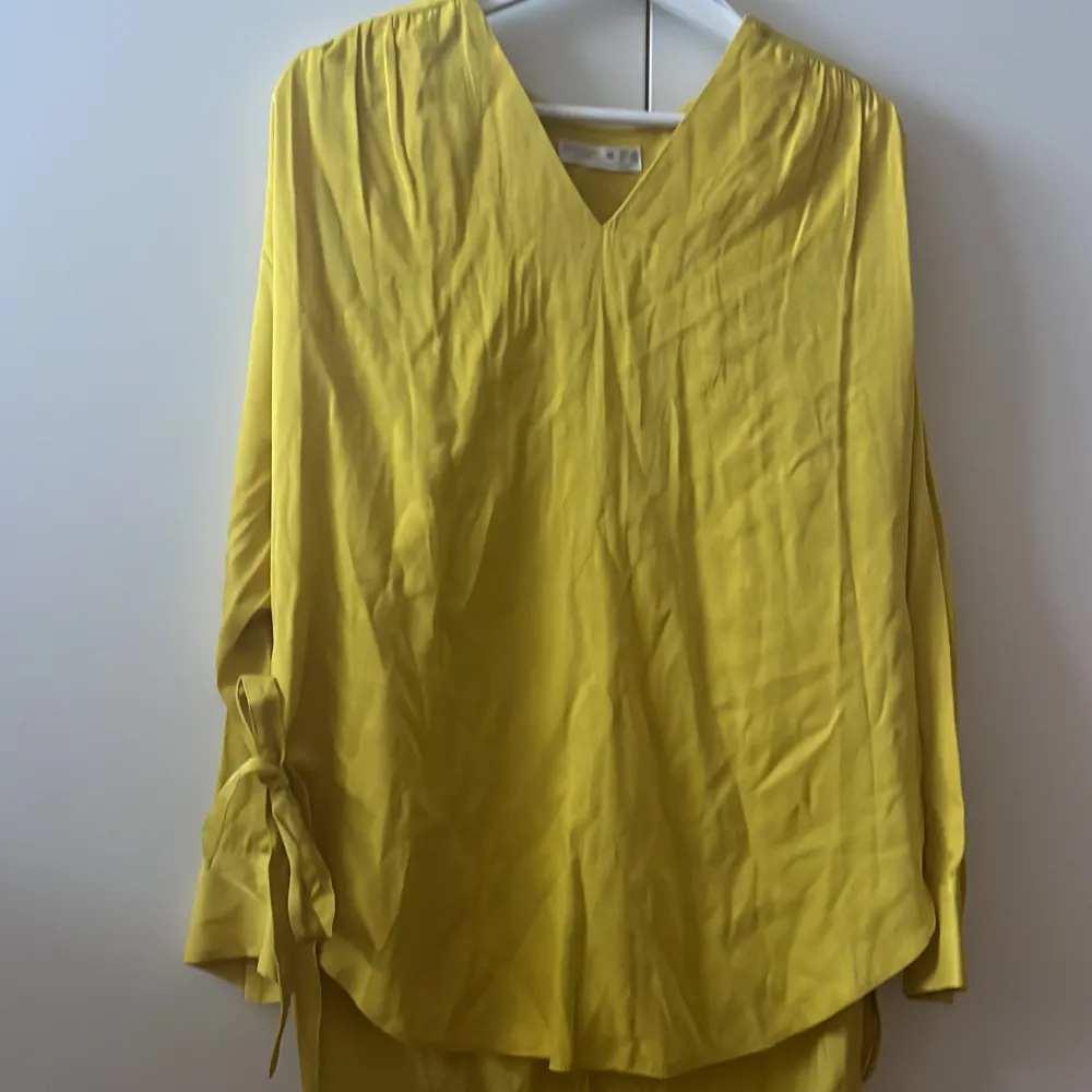 En gul Skjorta/klänning som har två söta band som kan knytas. Oanvänd och i bra skick. . Skjortor.