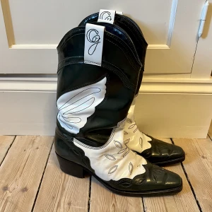 Ganni Western boots - I fint skick! Ena flärpen är lös på sidan, inget som stör vid användning. Går att åtgärda hos skomakare.  Storlek 41, jag har storlek 40 i vanliga fall. Har lagt i en sula för extra komfort. 