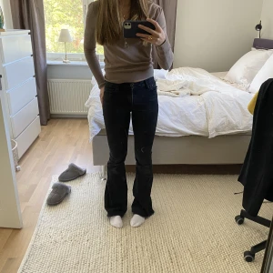 Mörkgrå bootcut jeans - Midwaist svart/grå bootcut jeans som jag älskar. Har tyvärr blivit för små. Har ett hål på benet och är utsvängda. ❤️😇säg till om ni vill ha fler bilder.