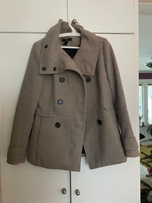 Kort kappa - Trendig kappa från HM. Storlek 38 men passar mig som har xs bra. Brun/beige färg. Som ny. 