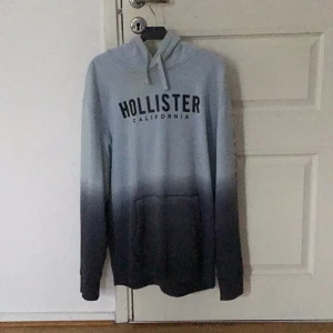HOLLISTER  - En hollister tröja med luva som är i bra skick. På ena armen står de ”Hollister”. Olika blå varianter har denna tröja. Den är i storlek XL men den är inte alls så stor. Jag hade sagt att det är en L. 