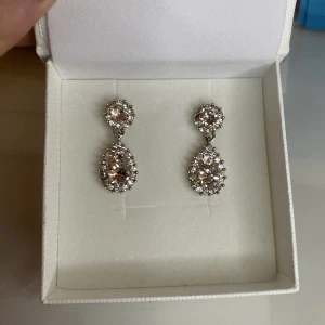 Örhängen  - Äkta Swarowski örhängen i rosé och silver. Nypris 500kr och är i gott skick. Finns i Södertälje men kan postas. 