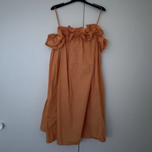 Klänning  - Kort klänning med volang. Tycker att den passar ifrån storlek M-XL. Använd 1 gång.