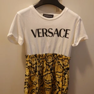 Versace klänning för 5 åring - Versace klänning för 5 åring. Motsvarar storlek 110/116. Min dotter har storlek 98/104 och det syns inte att den är jätte förstor.