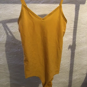 Body - Gul/orange body i storlek XS.