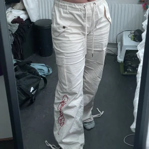 Ed Hardy cargo dam - Benvita cargos med tryck på högervad och text på vänster framsida ben. Bra skick, oanvända. Ligger fortfarande i påse med etikett. Storlek L. Kontakta för mer bilder :) skriv för intresse.