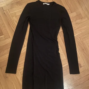 Tight svart klänning - Tight svar klänning från Alexander Wang, detaljer i form av söm samt lite omlotttyg.  Strl xs ( passar även s)