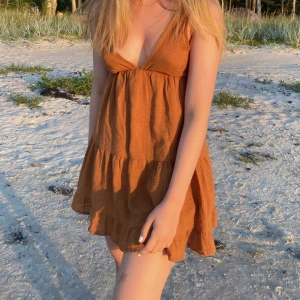 Rostfärgad klänning från Pull & Bear - Klänningen har även en V ringning i ryggen. Så fin, men har tyvärr växt ur den! Kan mötas upp i Stockholm annars står köparen för frakt💖