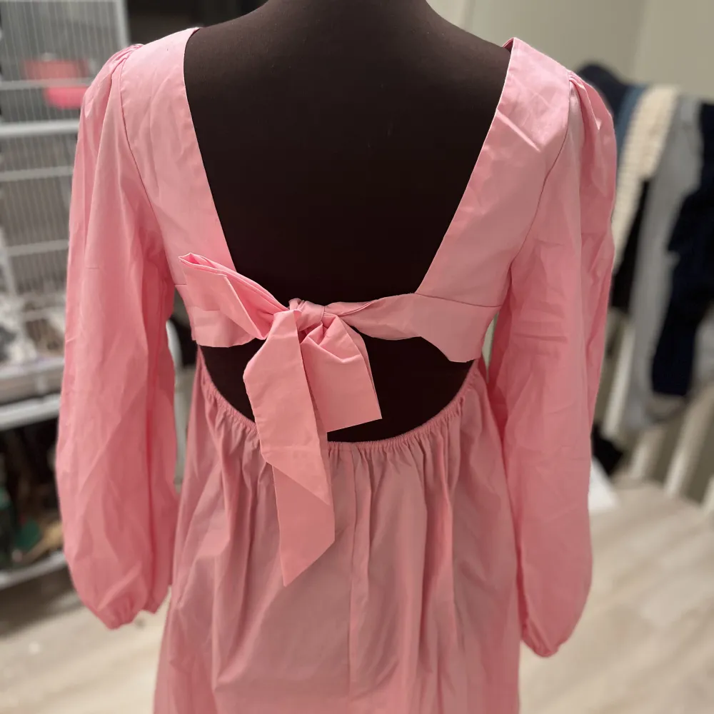 En jättesöt rosa klänning med rosett där bak som tyvärr är för stor för mig :/. Mekot.