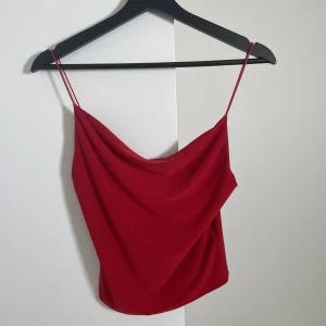 Röd croptop - Skitsnygg röd crop top med waterfall neckline. Säljer den för att banden är liite för långa och ramlar av på mig som är petite storlek 36 men den är perfekt för någon som är lite längre :) 