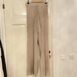 Byxa från Boohoo - En beige och härlig byxa från Boohoo som är helt oanvänd med prislapp kvar. Är i storlek 36 men sitter lite pösigare och är lång, men det kan enkelt kortas. 