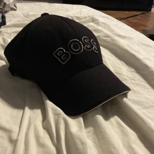 Boss keps - Säljer bosskepsen pga köpa ny, är i onesize men är justerbar som du ser på bilden, är i hur fint skick som helst och är inte andvänd mycke!