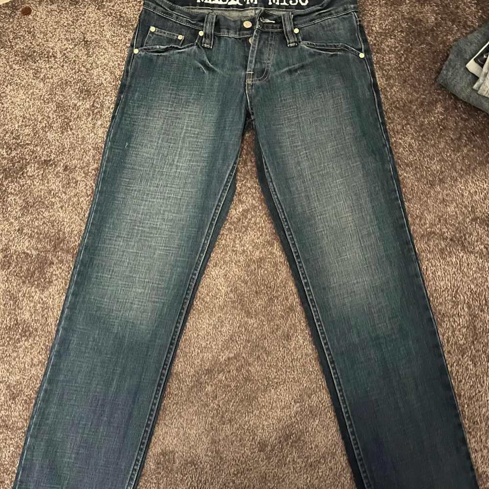 Blåa lågmidjade trendiga jeans. Storlek M men passar även S beroende på hur man vill att de ska sitta. Väldigt långa i modellen. Jeans & Byxor.