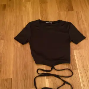 En svart t-shirt med snören, helt oanvänd