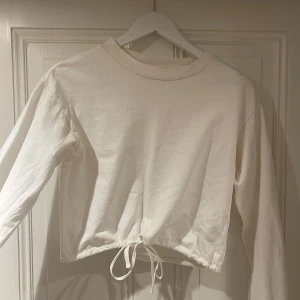 Sweatshirt från nelly - Vit sweatshirt från Nelly med snörning i midjan, storlek S. 60kr+frakt 