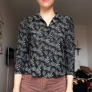 Blommig topp - Vintage topp köpt på Beyond retro i tunt tyg. Den har knappar framtill och krage!