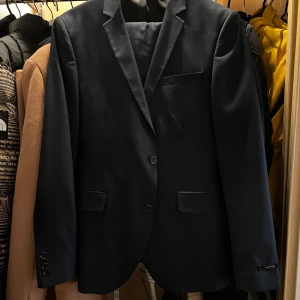Kostym storlek 48 - Kostym från Jack and Jones i mörkblå färg. Storlek M, väldigt bra skick. Använt fåtal gånger. Kavaj + Byxor