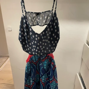 Klänning - Otroligt vacker klänning från Gina tricot, med öppen rygg, cutout och asymmetrisk kjol med mycket färg och mönster! Så otroligt härlig men säljes pga. för liten!