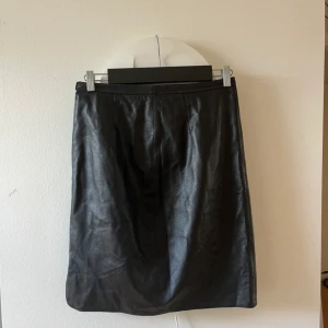 Vintage Vera Pelle skirt - ”Läder”Kjol i 100% viskos från Vera Pelle. Köpt second hand, aldrig använd av mig. Några lösa sömmar på innerkjolen (se bild 3). Ingen storlek finns på plagget men skulle chansa på S/M.