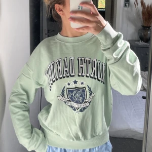 College sweater - Säljer nu min pastel gröna collage sweater från gina!! säljer då den inte längre kommer till användning. Lite slitning på trycket men inget man lägger märke till🫶🏼storlek xs