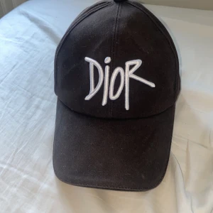 Dior keps - Den är i bra skick använd bara ett fåtal gånger.  Boxen och tyg påse får man självklart med.  Kom med pris! 