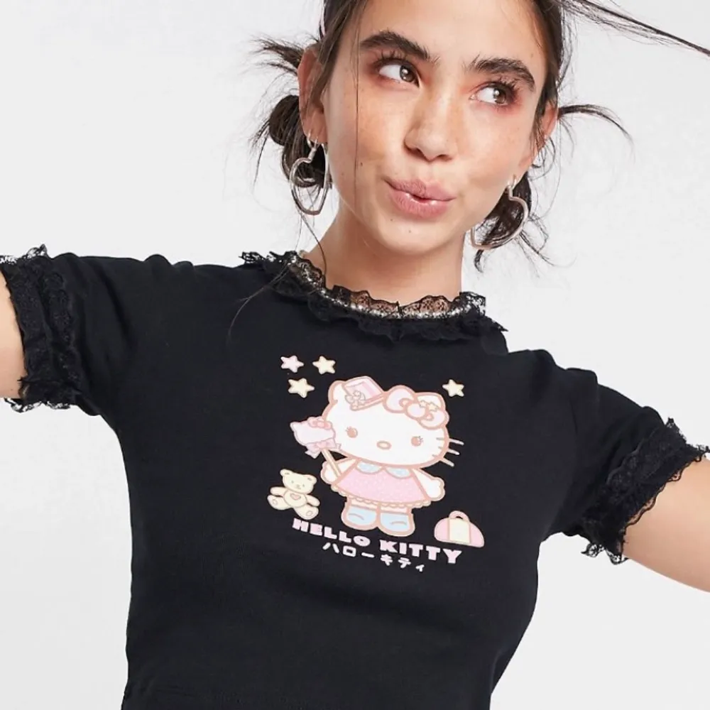 Jättesöt croppad Hello Kitty tröja från New Girl Order med söta spetsdetaljer runt halsen och armarna! Första bilden är hur den ser ut på modellen (bild från ASOS) Strl 12 passar som S/M. Köparen står för frakten! 🎀. Skjortor.