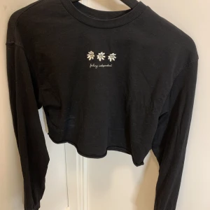 Svart topp - En svart topp med blommor 