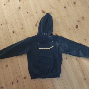 Dream hoodie - En svarr hoodie med guld smile från dreams officiella merchsida. Bra skick!