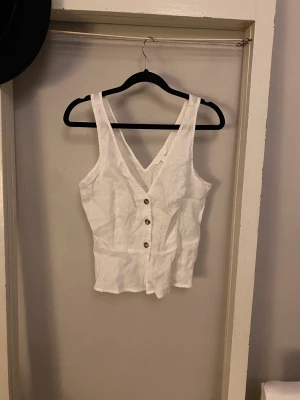 Topp i linne - Säljer en fin somrig topp i linne. V ringad fram och bak, fungerande knappar.  Säljer pga lite liten för mig 💗