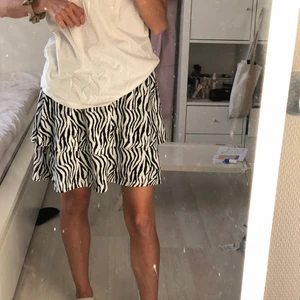 Volangkjol  - En fin volangkjol i zebra mönster. Den är väldigt strechig i midjan och passar någon  med xs/s i storlek.