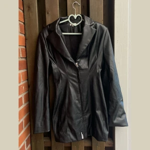 Supersnygg skinnjacka från Mistress Rocks! - Jacka från Mistress Rocks i skinnimitation. Har en jättesnygg passform då den är figursydd. Fungerar även att ha som klänning! 