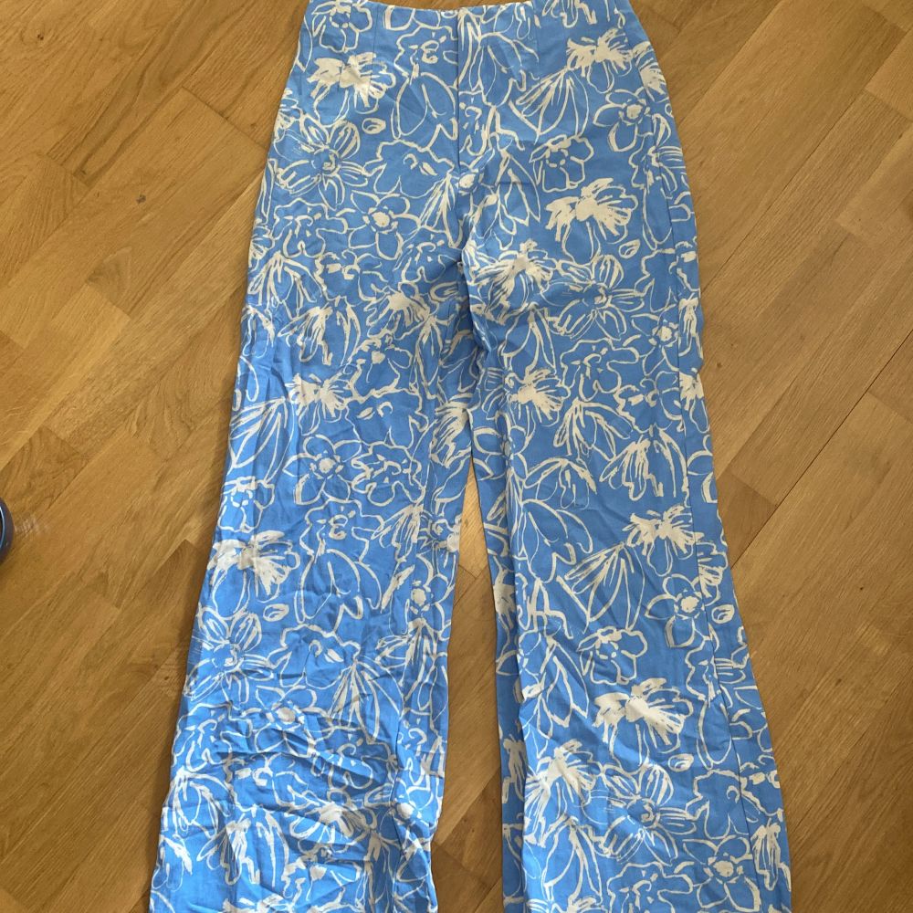 Blommmiga blåa kostymbyxor från Zara, helt nyckick. Orginal pris 399kr Storlek M. Jeans & Byxor.