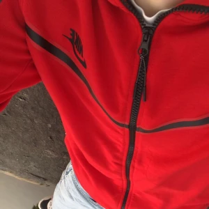 Röd Nike tech - Röd Nike tech med lite defekter  Står att den är storlek L men sitter som s