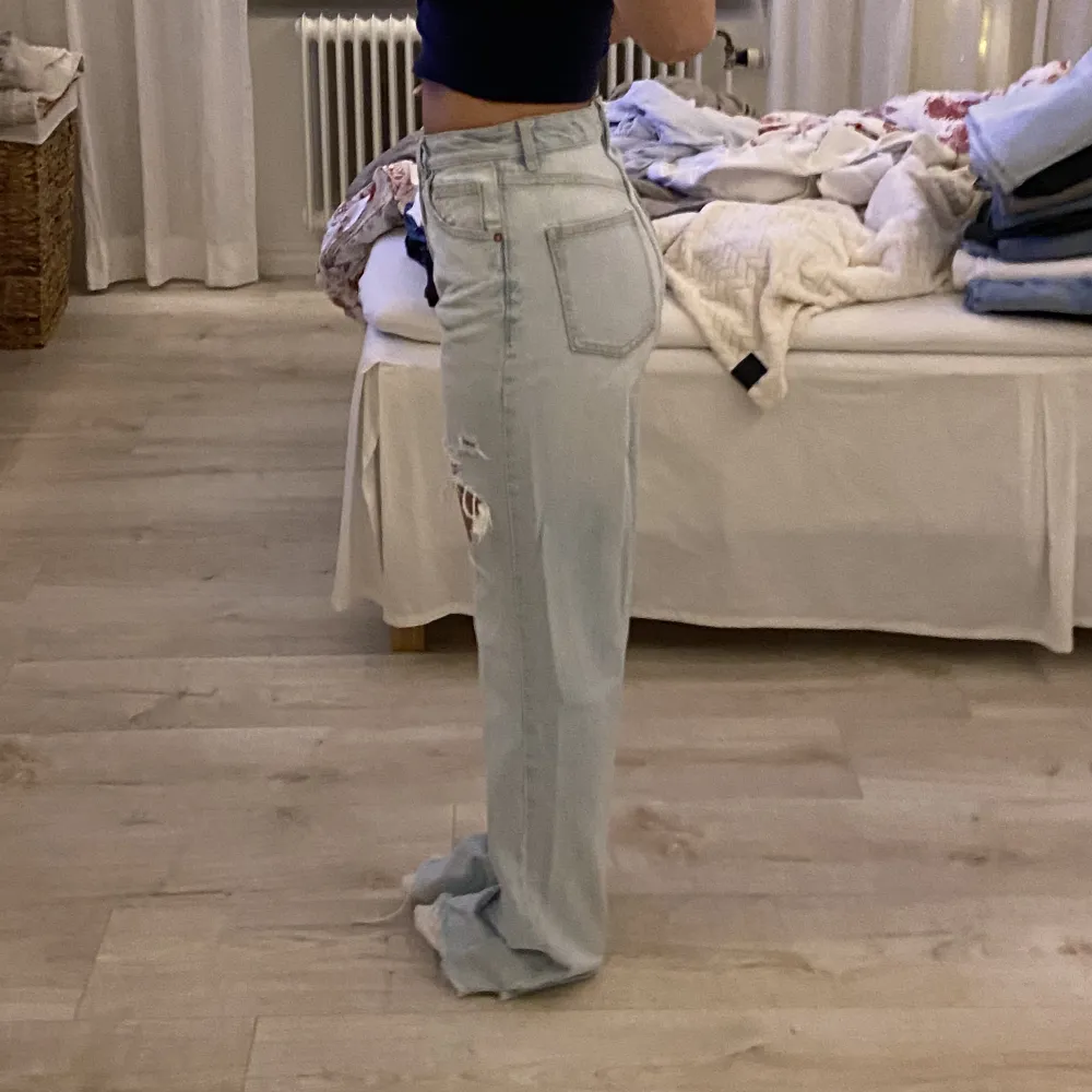 Snygga högmidjade jeans från Zara med slitningar på låren. Väldigt långa på mig som är 168, går att klippa av. Kommer tyvärr ej till användning pga förstora. Sparsamt använda. Budning om fler är intresserade 🤍. Jeans & Byxor.