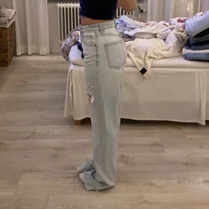 Zara Jeans Högmidjade  - Snygga högmidjade jeans från Zara med slitningar på låren. Väldigt långa på mig som är 168, går att klippa av. Kommer tyvärr ej till användning pga förstora. Sparsamt använda. Budning om fler är intresserade 🤍