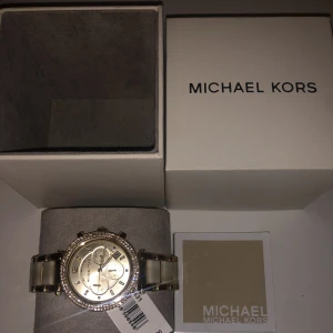 Äkta oanvänd Michael Kors klocka  - En helt ny äkta  Michael Kors klocka. Köptes för  (329€) ungefär 4000kr .Klockan har fortfarande prislappen kvar , kommer med bok och lådan den kom i . Kommer inte till användning. Kontakta mig för fler bilder, och vid intresse. Klicka INTE köp nu!🤍