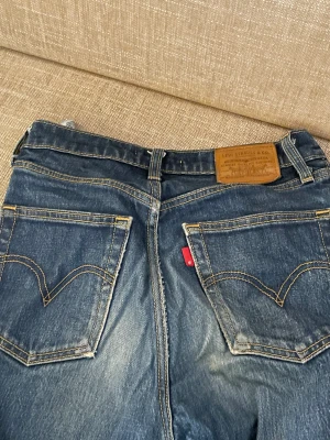 utsvängda levisjeans - säljer dessa ascoola och trendiga utsvängda levis jeans med supercoola sömmar på fickorna! jeansen är långa, mörkblåa och midwaist! säljer för att jag som är 173 har växt ur de. köptes för 1000kr och priset kan diskuteras💙(modellen ribcage boot)