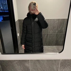 Lång dunjacka  - Svart lång dunjacka från lager 157, ca 1 år gammal. Inga slitningar eller så på den😊Jag är 169 lång! skriv om du har fler frågor! Jag 