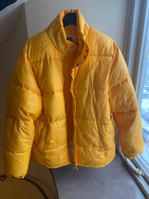 Gul vinterjacka från Weekday, strl M - Fin, varm vinterjacka i gult från weekday. Storlek M i unisex storlek, så en ganska stor medium alltså! 
