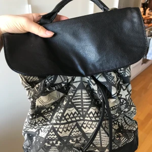 Coachella ryggsäck i svart och vitt - Ryggsäck från Bikboks AP Coachella kollektion ca år 2013 i svart och vitt mönster med läderimitation. Var en av mina favoriter så den är lite nött vid handtaget, men tycker det ger lite karaktär till just denna:) 