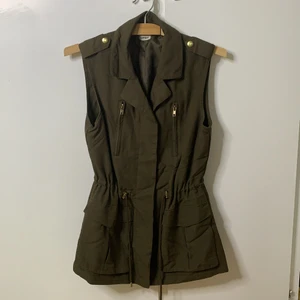 Pimkie ärmlös väst - Ärmlös, halvlång väst att bära med jeans eller en minikjol för en feminin och ganska sexig militärlook. 