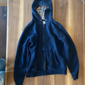 Burberry Zip Up Hoodie - Burberry zip up, köpt på stadsmissionen så är osäker på om den är äkta men den ser bra ut iallafall så den är säkert äkta.