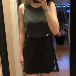 klänning - en svart/grå klänning med fake läder kjol som är väldigt stor runt midjan, den har dragkedja i kjolen så att det ska vara lätt att ta på sig