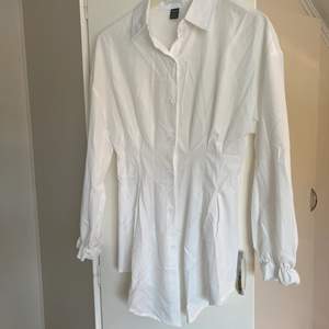 En lite längre vit skjorta från shein, smalnar in vid midjan. Aldrig använd.