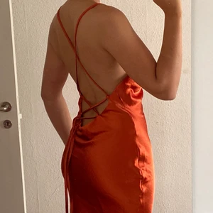 Satinklänning - Helt ny satinklänning i en oerhört fin rostig färg. Skulle använt på bröllop som inte blev av där av är den helt oanvänd med lappar kvar. Den är 5c över marken på mig som är 175 men då har jag den ganska långt ner (spänner man den så blir kjolen kortare o