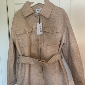 Jacka med bälte - En helt oanvänd jacka med bälte i midjan.