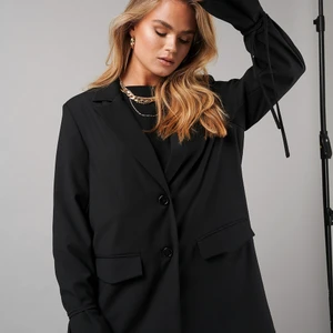 Kavaj NA-KD Hanna Schönberg strl 38 - Svart kavaj från Hanna Schönberg kollektion med NA-KD, med bad vid ärmarna. I strl 38, funkar bra som klänningen är själv 180cm lång. Sällan använd 