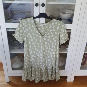 Mönstrad miniklänning - Monki (XXS) - Ljusgrön miniklänning med vita prickar i lös modell. Vida ärmar och knäppning framtill. Något stor i storleken.